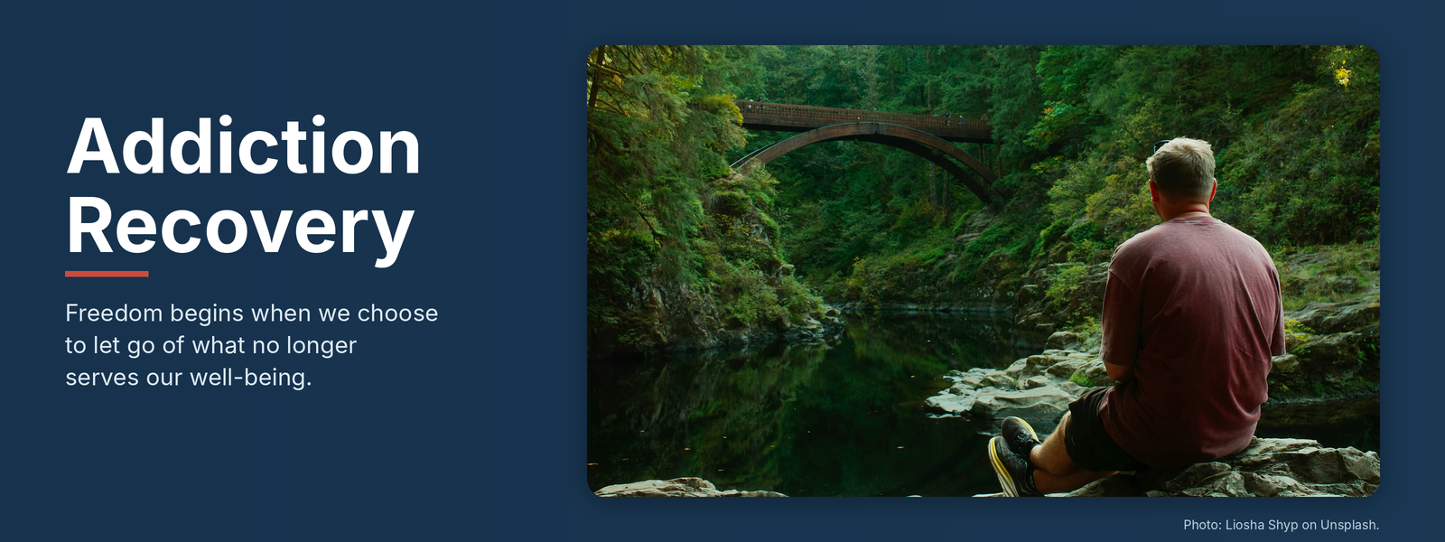 Addiction Recovery banner with a man sitting on rocks looking at a forest bridge over a calm river